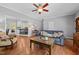 Inviting living room features hardwood floors, a ceiling fan, and a partial view to kitchen at 910 S Third St, Mebane, NC 27302