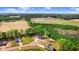 Aerial view of home surrounded by mature trees, open fields, and a serene pond at 9200 Otter Ct, Middlesex, NC 27557