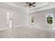 Primary bedroom with two windows, tray ceiling and ensuite bathroom at 9200 Otter Ct, Middlesex, NC 27557