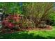Landscaped backyard featuring a wooden bench, fence and a variety of flowering bushes at 102 Antler Point Rd, Chapel Hill, NC 27516