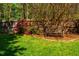 Landscaped backyard with a wooden bench, a fence, and blooming bushes at 102 Antler Point Rd, Chapel Hill, NC 27516