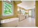 Bright bathroom featuring a modern soaking tub, double vanities, and a glass-enclosed marble shower at 102 Antler Point Rd, Chapel Hill, NC 27516