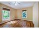 Bedroom with hardwood floors, ceiling fan, and natural light from two windows at 102 Antler Point Rd, Chapel Hill, NC 27516