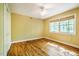 Comfortable bedroom with hardwood floors, ceiling fan, and natural light from two windows at 102 Antler Point Rd, Chapel Hill, NC 27516