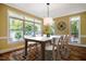 Inviting dining room with large windows, a modern light fixture, and seating for six at 102 Antler Point Rd, Chapel Hill, NC 27516