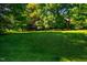 A beautifully landscaped front yard featuring mature trees and a well-maintained lawn at 102 Antler Point Rd, Chapel Hill, NC 27516