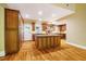 Wide kitchen view of stainless appliances, central island, custom cabinetry and hardwood flooring at 102 Antler Point Rd, Chapel Hill, NC 27516