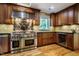 Gourmet kitchen features stainless steel appliances, custom cabinets, and a black marble backsplash at 102 Antler Point Rd, Chapel Hill, NC 27516