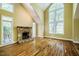 Spacious living room with hardwood floors, a stone fireplace and soaring arched windows at 102 Antler Point Rd, Chapel Hill, NC 27516