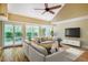 Bright living room with modern furnishings, large windows, hardwood floors, and a ceiling fan at 102 Antler Point Rd, Chapel Hill, NC 27516