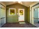 Charming porch with brick flooring, green siding, and a secure entryway at 102 Antler Point Rd, Chapel Hill, NC 27516