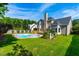 Beautiful backyard featuring a pool, deck, manicured lawn, and mature trees at 102 Traviliah Oaks Ln, Cary, NC 27518