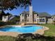Backyard featuring an inground pool, wooden deck, and well-maintained landscaping at 102 Traviliah Oaks Ln, Cary, NC 27518