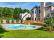 Outdoor in-ground pool surrounded by a deck and green lawn at 102 Traviliah Oaks Ln, Cary, NC 27518