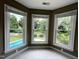 Corner bedroom featuring three windows with backyard and pool views at 102 Traviliah Oaks Ln, Cary, NC 27518