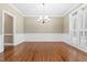 Elegant dining room with hardwood floors, wainscoting, chandelier, and large shuttered windows at 102 Traviliah Oaks Ln, Cary, NC 27518
