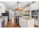 Gourmet kitchen with granite countertops, stainless steel appliances, and custom wood range hood at 102 Traviliah Oaks Ln, Cary, NC 27518