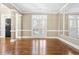 Spacious room with hardwood floors, large shuttered windows, and elegant molding at 102 Traviliah Oaks Ln, Cary, NC 27518