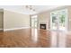Bright living room featuring a fireplace, ceiling fans, and access to the outdoor patio at 102 Traviliah Oaks Ln, Cary, NC 27518