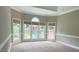 Main bedroom with tray ceiling features large windows overlooking the pool, bringing lots of natural light to this retreat at 102 Traviliah Oaks Ln, Cary, NC 27518