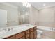 A full bathroom featuring double sinks, tub, and glass shower at 103 Aisling Ct, Cary, NC 27513