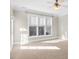 Bright bedroom featuring tan carpet, a ceiling fan, and large windows at 103 Aisling Ct, Cary, NC 27513