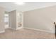 Spacious bedroom boasting neutral walls, plush carpet, and ample natural light from a doorway leading to a bathroom at 103 Aisling Ct, Cary, NC 27513