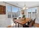 Bright dining room featuring a rustic wood table, chandelier, and large windows with shutters at 103 Aisling Ct, Cary, NC 27513