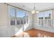 Sunlit dining room with hardwood floors, wainscoting, and large windows at 103 Aisling Ct, Cary, NC 27513