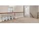 Second floor hallway featuring neutral carpet and wrought iron railing at 103 Aisling Ct, Cary, NC 27513