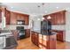 Kitchen featuring dark wood cabinets, black appliances, and an island for prepping at 103 Aisling Ct, Cary, NC 27513