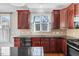 Kitchen with dark wood cabinets, black appliances, and ample countertop space at 103 Aisling Ct, Cary, NC 27513