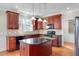 Kitchen with cherry cabinets, granite countertops, and a modern black appliance package at 103 Aisling Ct, Cary, NC 27513