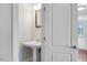 A simple powder room featuring a white pedestal sink and a mirror at 103 Aisling Ct, Cary, NC 27513