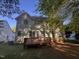 The back of this two-story home offers a wooden deck and multiple windows and is surrounded by mature trees at 105 Dairy Ct, Chapel Hill, NC 27516