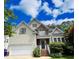 Charming two-story home featuring a symmetrical design, light siding, brick accents, and an attached two-car garage at 105 Dairy Ct, Chapel Hill, NC 27516