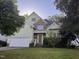 Inviting two-story home with a well-manicured lawn, complemented by mature trees and lush shrubbery around the property at 105 Dairy Ct, Chapel Hill, NC 27516