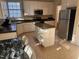 Well-lit kitchen with a central island, black appliances, and open access to the living room at 105 Dairy Ct, Chapel Hill, NC 27516