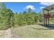 Exterior view of a backyard featuring a raised deck, lush greenery and a view of surrounding trees at 106 Neuse Bluff Cir, Clayton, NC 27527