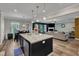 Open-concept kitchen with a center island, granite counters, and stainless steel appliances, flowing into the living area at 106 Neuse Bluff Cir, Clayton, NC 27527