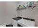 Functional laundry room with modern washer and dryer units and shelving for storage and organization at 106 Neuse Bluff Cir, Clayton, NC 27527