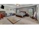 Large main bedroom featuring tray ceiling, crib, patterned wallpaper, and ample natural light at 106 Neuse Bluff Cir, Clayton, NC 27527