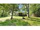 Expansive backyard with mature trees, a lush lawn, and a screened-in porch extending from the rear of the home at 109 Stone Ridge Dr, Smithfield, NC 27577
