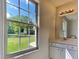 Bright bathroom showcasing marble countertop, white cabinetry, and a window with an expansive green lawn view at 109 Stone Ridge Dr, Smithfield, NC 27577