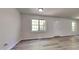 Bright, open living room with modern flooring, two windows, and a white front door at 109 Stone Ridge Dr, Smithfield, NC 27577