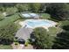Aerial view of a sparkling pool, tennis courts, clubhouse, and manicured green space at 110 Chapelwood Way, Cary, NC 27518