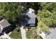 Aerial view of gray home featuring a pool, outdoor kitchen, mature trees, and lush landscaping at 110 Chapelwood Way, Cary, NC 27518