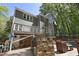 Backyard view of gray home with white trim, stone outdoor kitchen, deck, and swimming pool at 110 Chapelwood Way, Cary, NC 27518