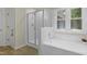 Bathroom featuring a glass shower, tub, and large window at 110 Chapelwood Way, Cary, NC 27518