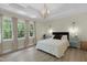 Calm bedroom with tray ceiling, elegant chandelier, and three large bright windows at 110 Chapelwood Way, Cary, NC 27518